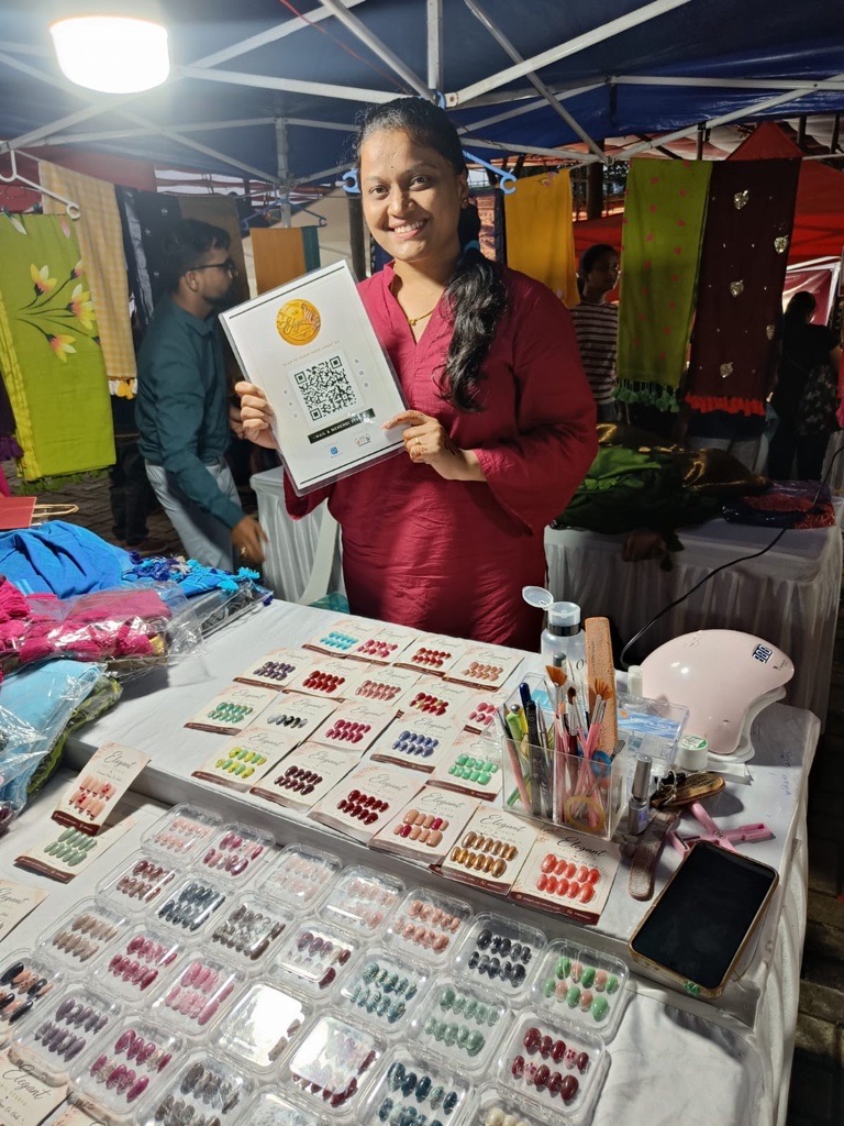 Elegant Nail Studio stall with a ReviewLoop QR flyer at a market counter