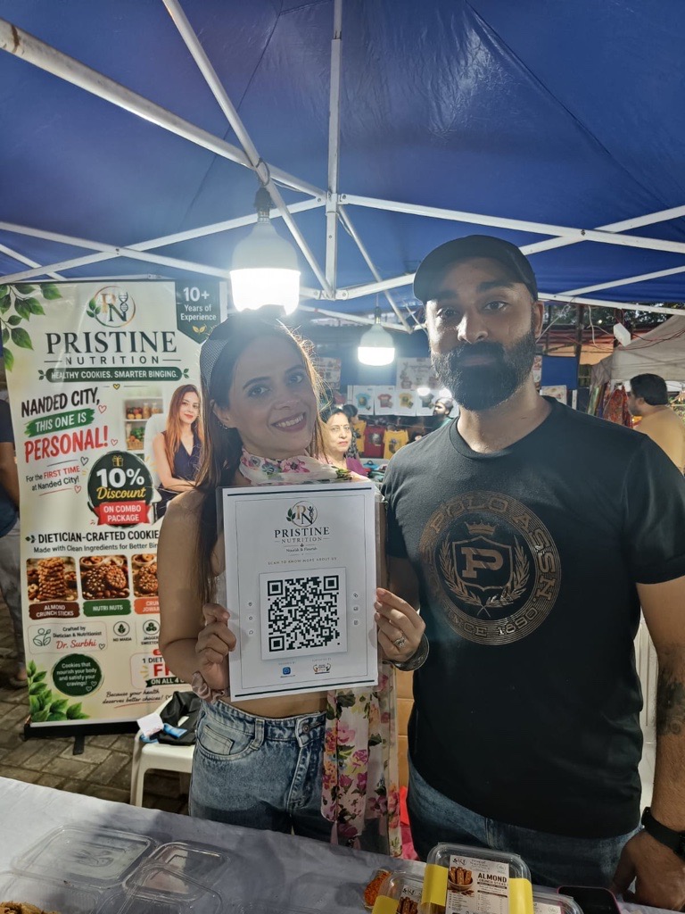Pristine Nutrition team holding a ReviewLoop QR flyer at their stall