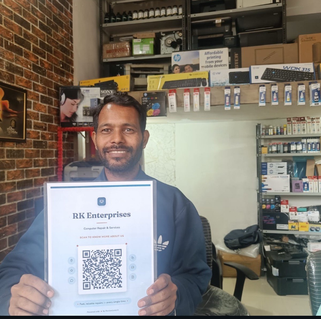RK Enterprises owner with ReviewLoop QR stand in computer repair shop